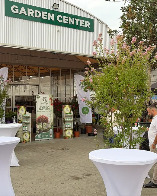Montaje de un evento en el centro de jardinería con escenario y el expositor de Ecoalga al fondo